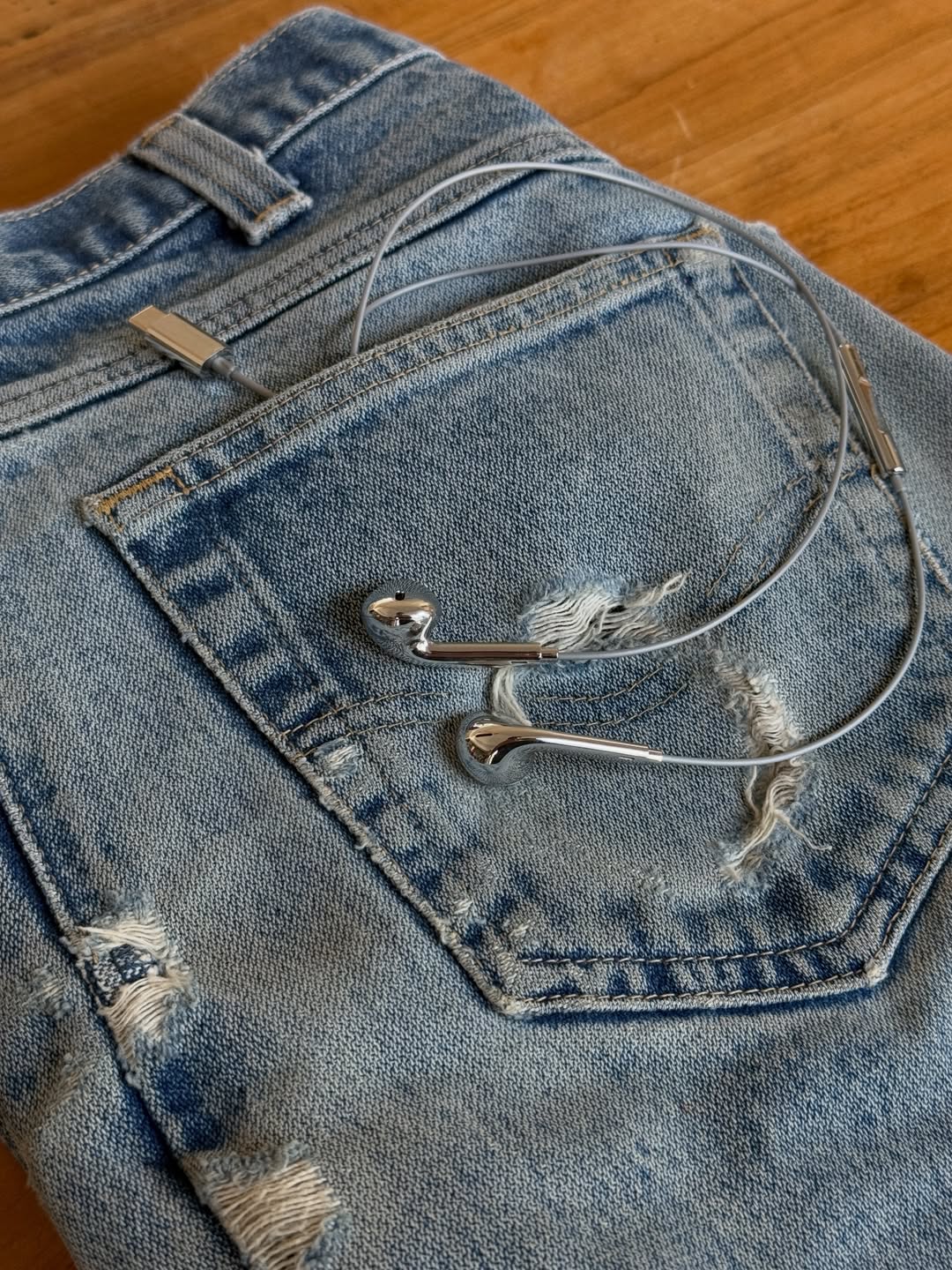 Earphones tucked in jeans pocket